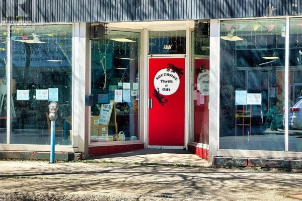 A retail display area with shelves of pillows, a clock, and glass display cases. - 507 Victoria Ave E, Thunder Bay