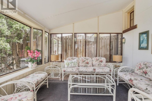 Backyard with a kidney-shaped swimming pool, patio furniture, and mature trees. - 5079 Armoury Street, Niagara Falls