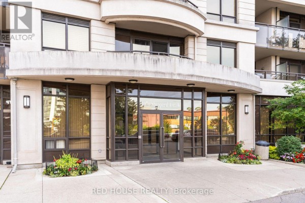 Entrance to the condominium building at 1070 Sheppard Avenue West with glass doors and planters. - 508 - 1070 Sheppard Avenue W, Toronto