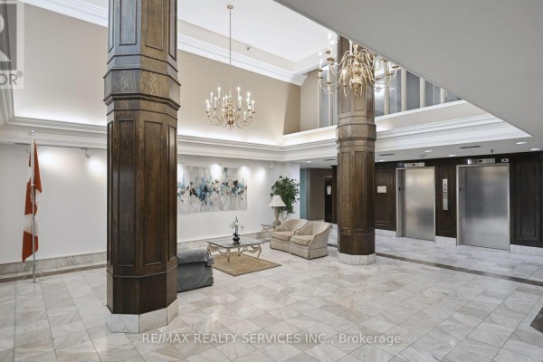 Building lobby with marble floors, ornate chandeliers, and two elevators. - 508 - 330 Mill Street S, Brampton
