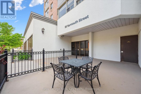 Bedroom with crib, dresser, air conditioning unit, and large window with view. - 508 - 55 Yarmouth Street, Guelph