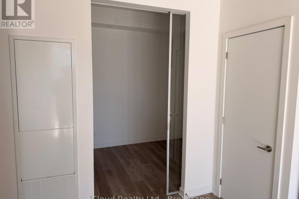 Hallway entrance with sliding glass doors to a room and a white door. - 508 - 91 John Street North Street, Hamilton