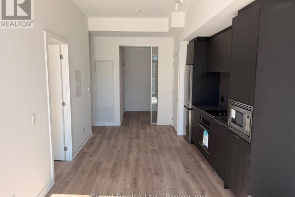 Open concept living area with a modern kitchen and entrance to other rooms. - 508 - 91 John Street North Street, Hamilton