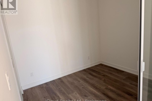 Empty room with white walls and light wood laminate flooring. - 508 - 91 John Street North Street, Hamilton