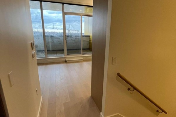 View from entryway into a room with sliding glass doors to a balcony. - 508 - 95 Mcmahon Drive, Toronto