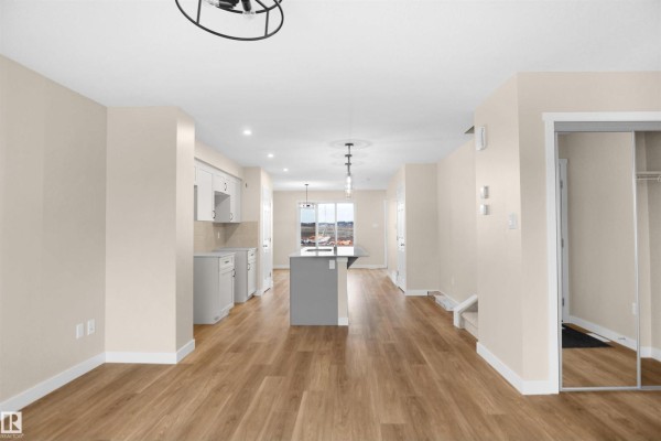 Open-concept layout featuring kitchen island, dining space, and natural light - 508 176 Av Ne, Edmonton