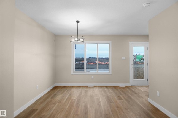 Cozy dining area with window view and access to outdoor space - 508 176 Av Ne, Edmonton