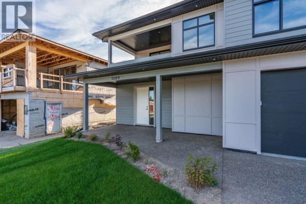 Spacious basement room with beige walls, wood floors, and a small window. - 5089 Headlands Heights, Prince George