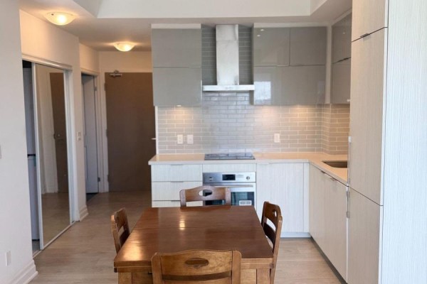 U-shaped kitchen with light grey backsplash, white counters, and light wood flooring. - 508b - 8 Rouge Valley Drive, Markham