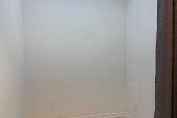 Empty room with white walls, light wood floors, and a brown curtain. - 508b - 8 Rouge Valley Drive, Markham