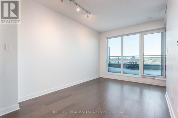 View from inside the apartment looking out the sliding glass doors and into another room with brick wall. - 509 - 1169 Queen Street W, Toronto