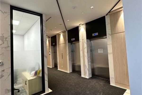Elevator lobby of the 30 Tretti Way building featuring stainless steel doors and wood paneling. - 509 - 30 Tretti Way, Toronto