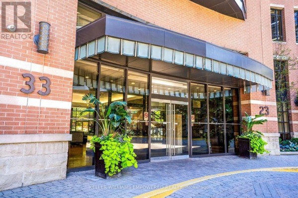 Glass double doors leading into the condo building lobby with potted plants. - 509 - 33 Sheppard Avenue E, Toronto