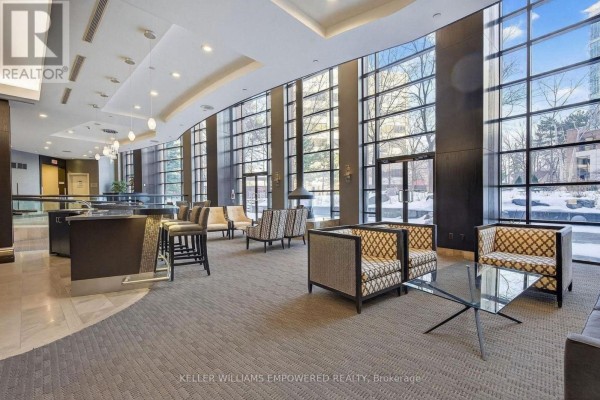 Hotel-style lobby with patterned armchairs, a wet bar, and large windows. - 509 - 33 Sheppard Avenue E, Toronto