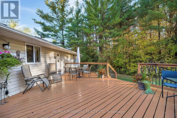 Another view of the large wooden deck with seating and potted plants. - 509 Concession 2 Road E, Trent Hills