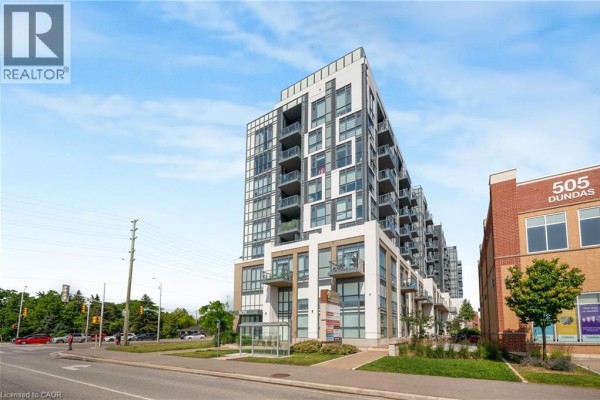 Side view of the 509 Dundas Street apartment building with nearby retail spaces and street. - 509 Dundas Street W Unit# 305, Oakville