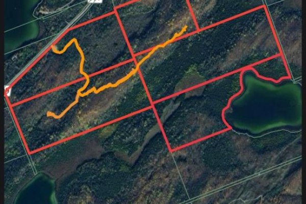 An aerial map shows property lines in red with orange trails winding through wooded terrain and lakes. - 509 Road Road, Frontenac