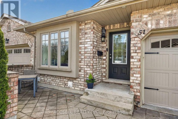 Close-up of townhouse entrance with brick facade, glass door, and garage. - 51 - 765 Killarney Road, London North