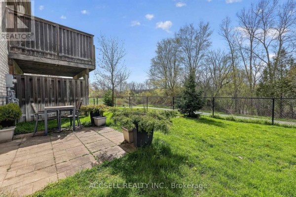 Paved patio area in backyard with table, chairs, and green lawn. - 51 - 765 Killarney Road, London North