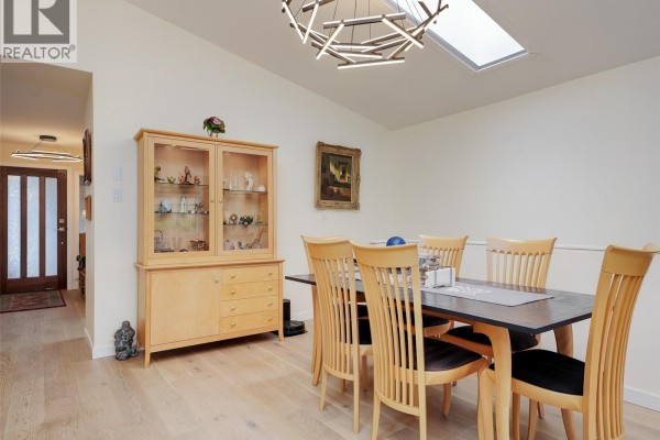Dining area with a wooden hutch, a dark rectangular table, and six wooden chairs. - 51 901 Kentwood Lane, Saanich