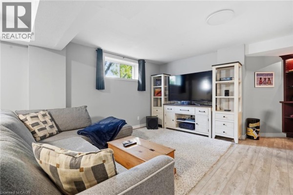 Sectional sofa, entertainment center with large TV, and wood flooring - 51 Autumn Ridge Trail Kitchener