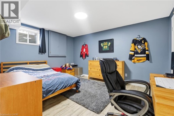 Bedroom with a bed, dresser, desk chair, and hockey jerseys - 51 Autumn Ridge Trail Kitchener