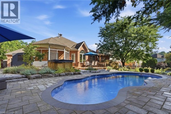 Backyard with swimming pool, hot tub, deck and covered porch - 51 Autumn Ridge Trail Kitchener