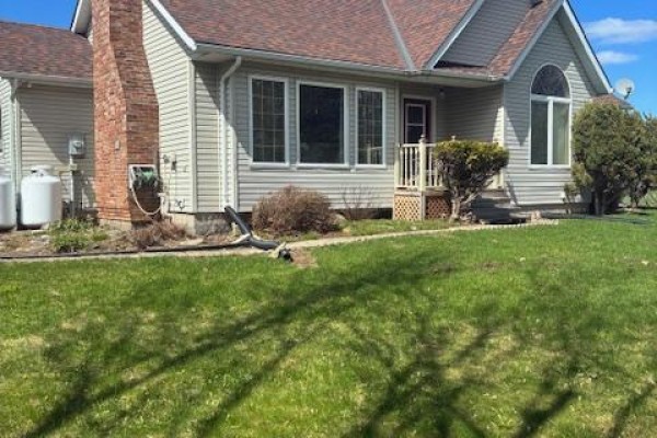 Rear exterior view of the house with two large white propane tanks and a brick chimney. - 51 B Jericho Road, Prince Edward County