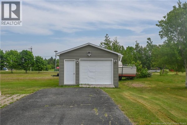 Kitchen with white cabinets, stainless steel appliances, granite countertops, and an island with seating. - 51 Chiasson Road, Savoie Landing