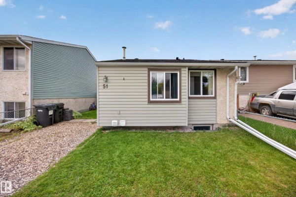 Front exterior of a light green house with brown trim and windows. Gravel driveway and grass yard. - 51 Chungo Dr, Devon