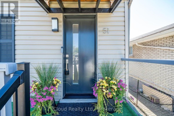 Detailed view of the front door with a glass insert, flanked by planters. - 51 Delena Avenue S, Hamilton