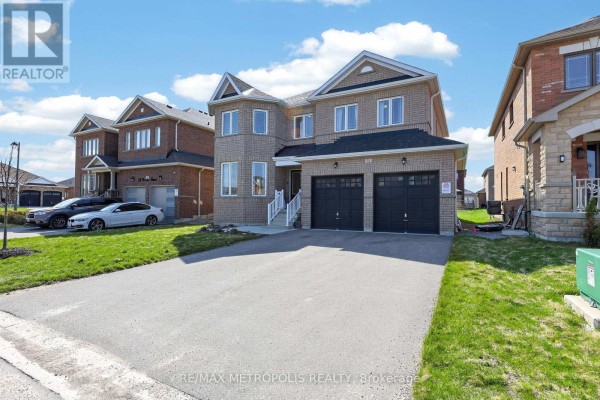 View of a modern brick house with a double garage and a driveway, flanked by similar houses. - 51 Furniss Street, Brock