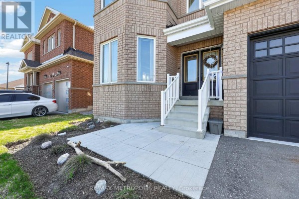 Close-up of the front entrance with concrete walkway, stairs, and a double garage door. - 51 Furniss Street, Brock