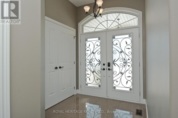 Interior view of a foyer with a closet and decorative double doors with an arched transom window. - 51 Gloria Crescent, Whitby