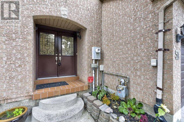 Close-up of the arched front entrance with double doors and brick steps. - 51 Goldenlight Circle, Brampton