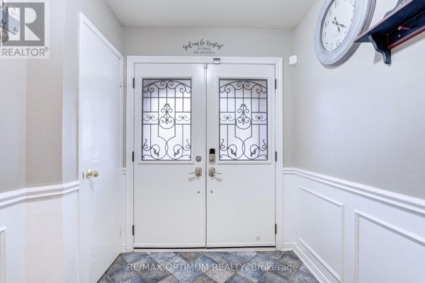 Interior view of a bright foyer with double white doors and wainscoting. - 51 Goldenlight Circle, Brampton