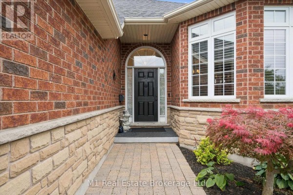 Close-up of the arched front entrance door, surrounded by brick and stone facade. - 51 Mcgowan Street, Centre Wellington
