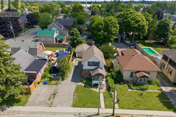 Aerial view looking down on the house and surrounding neighborhood with green trees. - 51 Melbourne Street W, Kawartha Lakes