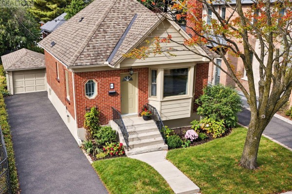 Aerial view of a red brick bungalow with a driveway and detached garage. - 51 Merritt Avenue, Ottawa