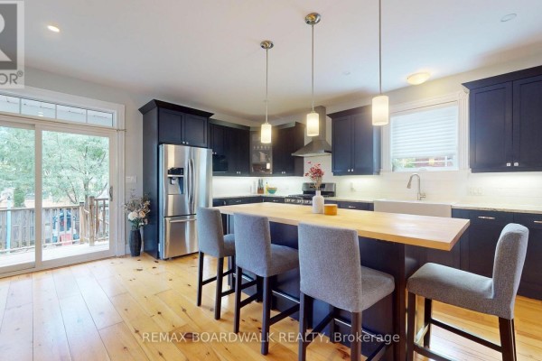 Modern kitchen with island, farmhouse sink, and blue cabinets - 51 Ormond Street Brockville