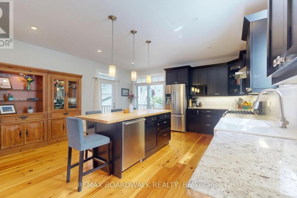 Modern kitchen with island, stainless steel appliances, and hardwood floors - 51 Ormond Street Brockville