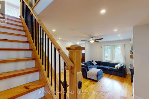 Living room with sectional sofa and wooden stairs - 51 Ormond Street Brockville