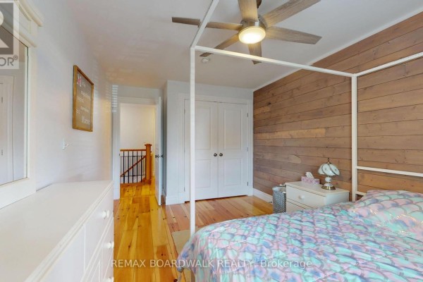 Bedroom with four-poster bed and wood accent wall - 51 Ormond Street Brockville