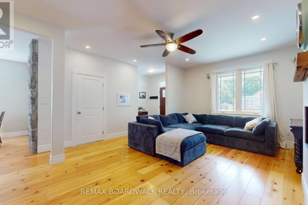 Living room with large sectional sofa, hardwood floors, ceiling fan - 51 Ormond Street Brockville