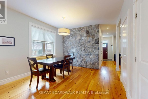 Dining room with stone wall, wood table & chairs - 51 Ormond Street Brockville
