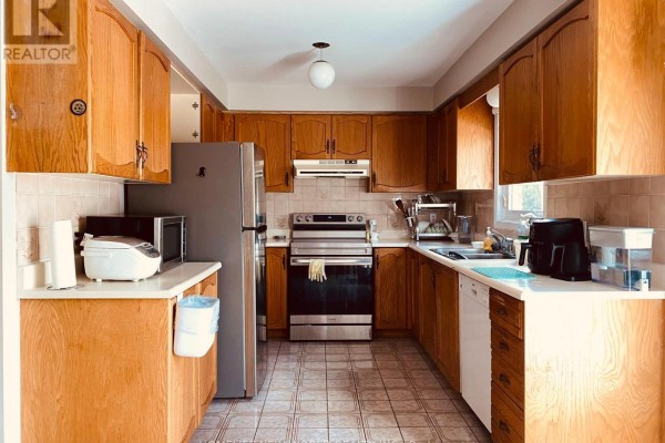 Kitchen with light oak cabinets, stainless steel appliances including a refrigerator and stove, and tiled floor. - 51 Park Lane Circle, Richmond Hill