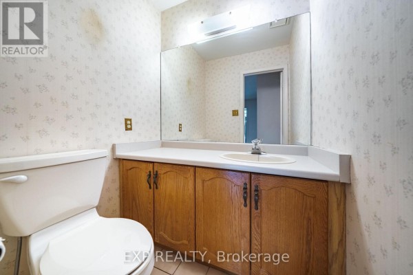 Bathroom with wooden vanity, sink, and mirror - 51 Sanderson Crescent Richmond Hill