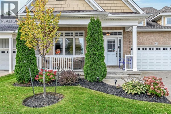 Front porch with wicker chairs, green shrubs, and flowering hydrangeas. - 51 Schooner Drive, Port Dover