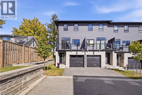 Exterior view of a row of modern townhouses with grey siding and garages. - 51 Sparrow Avenue Unit# 96, Cambridge
