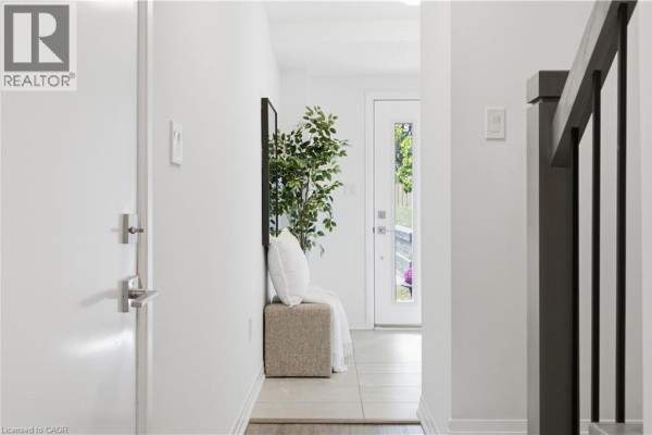 Interior hallway with white walls, a bench, and a glass-paneled door leading outside. - 51 Sparrow Avenue Unit# 96, Cambridge